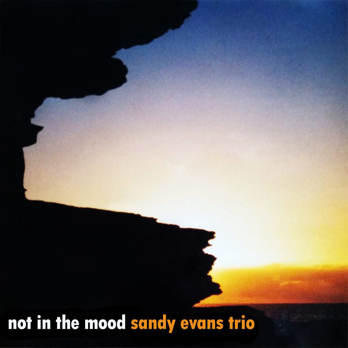 Not in the Mood cover: a rock headland in silhouette against an orange and yellow sunset