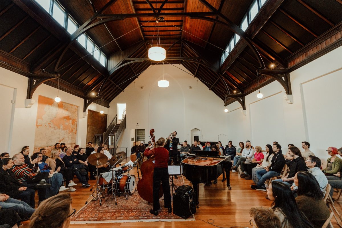 A quartet playing to a seated audience in a high-ceilinged hall